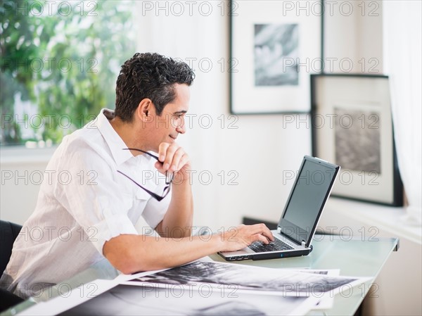 Portrait of man in his photography studio using laptop