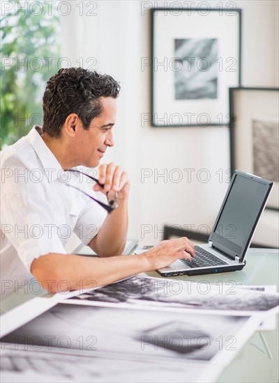 Portrait of man in his photography studio using laptop