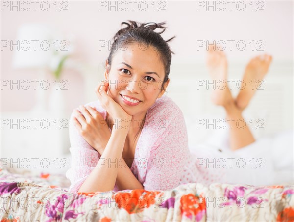 Portrait of mid adult woman lying on bed