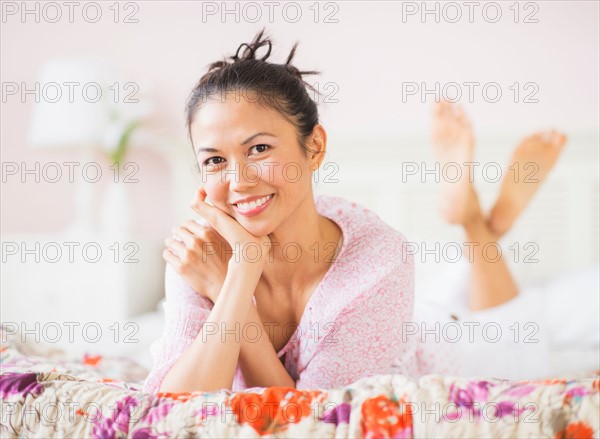 Portrait of mid adult woman lying on bed