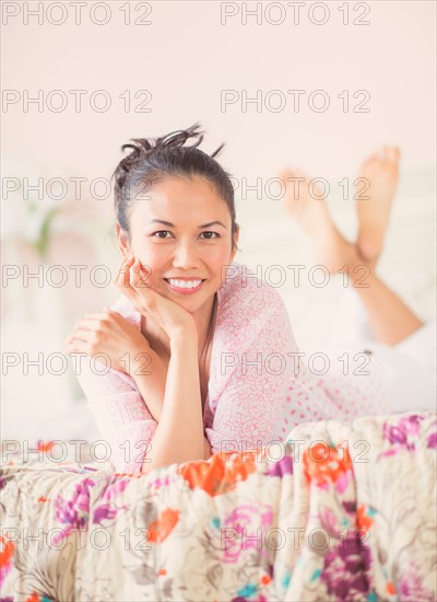 Portrait of mid adult woman lying on bed