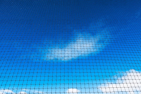 Grid-wire fence against sky