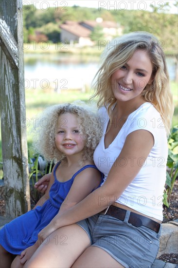 Mother with daughter (4-5) sitting outdoors