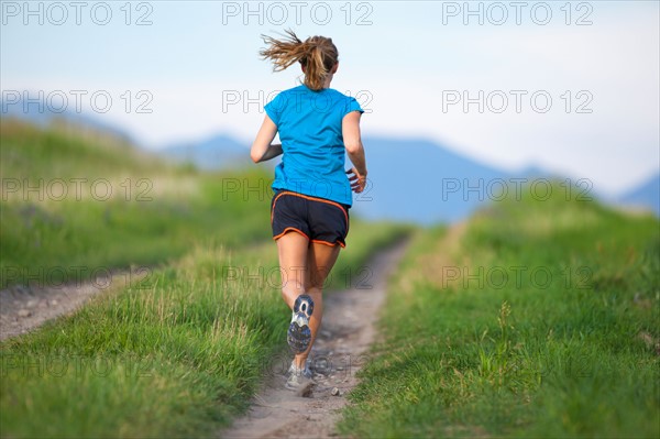 Rear view of young woman jogging