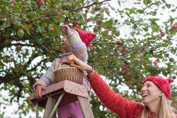 Mother and daughter picking up apples