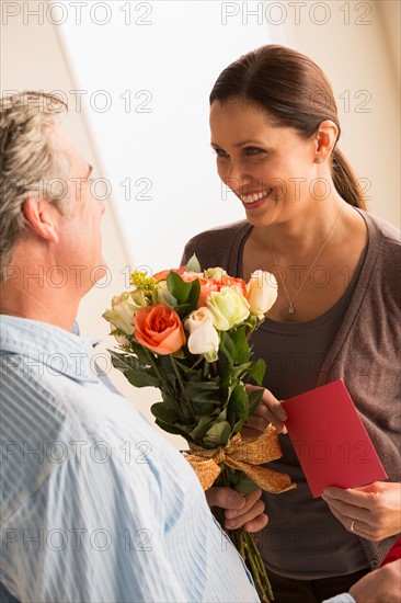 Mature woman receiving bouquet from mature man