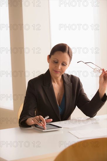 Mature business woman using digital tablet