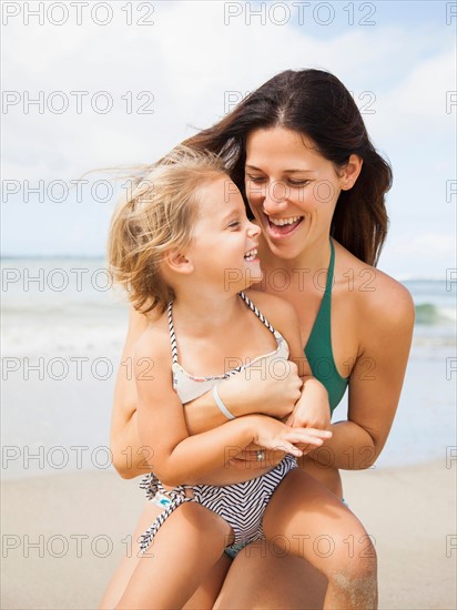 Mother with daughter (2-3) on beach