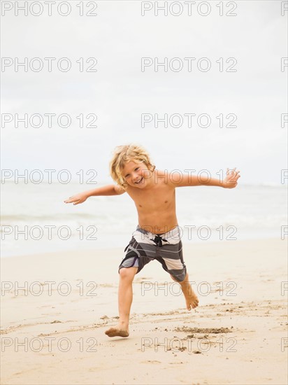 Boy (6-7) playing on beach