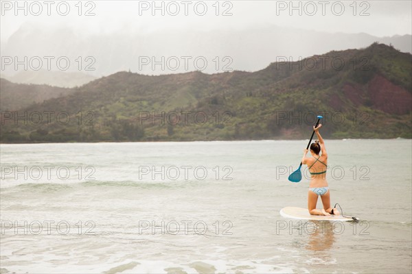 Woman paddling on shallow water