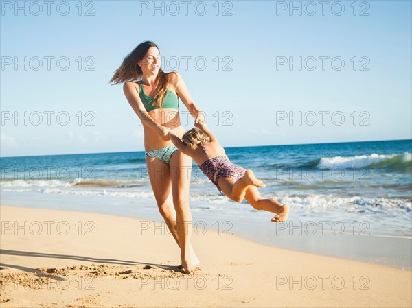 Mother playing with daughter (2-3) on beach