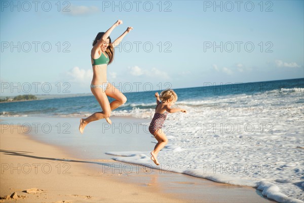 Mother with daughter (2-3) playing on beach