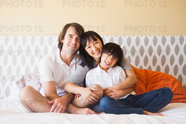 Portrait of family sitting on bed