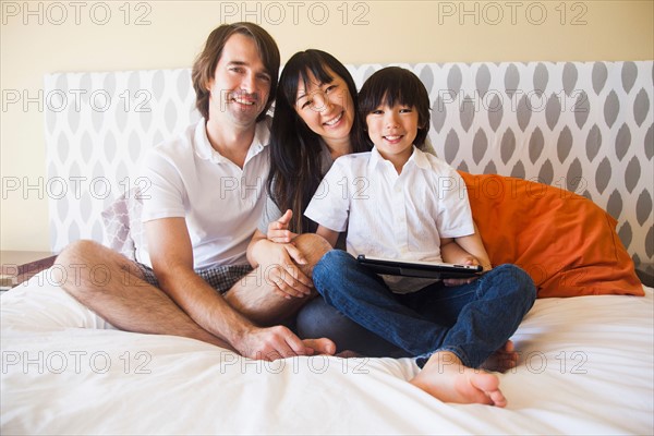 Portrait of family sitting on bed