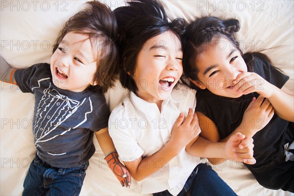 Portrait of siblings laying on bed