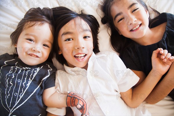 Portrait of siblings laying on bed