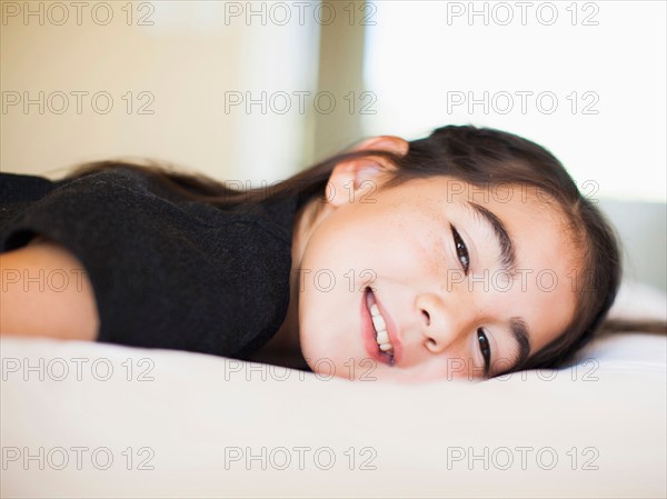 Portrait of girl (8-9) laying on bed