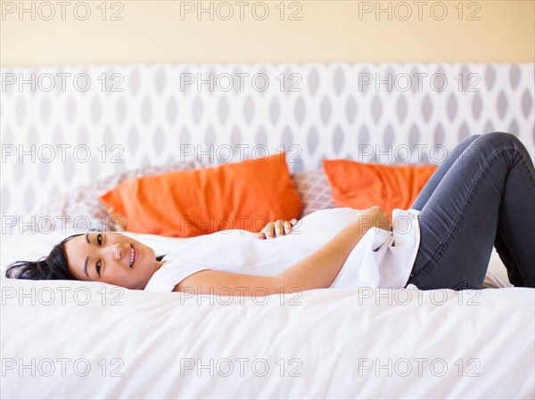 Pregnant woman lying on bed