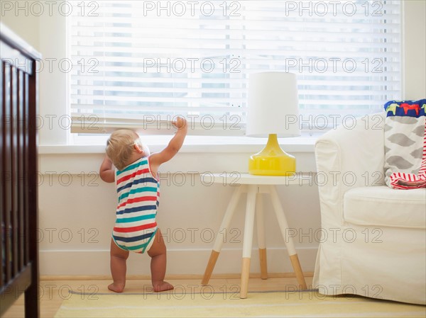 Baby boy (6-11 months) looking through window