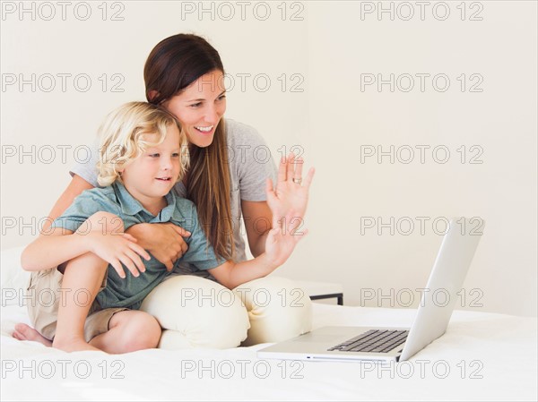 Mother with son (6-7) using laptop