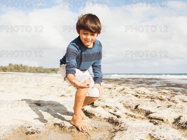 Boy (10-11) playing on beach