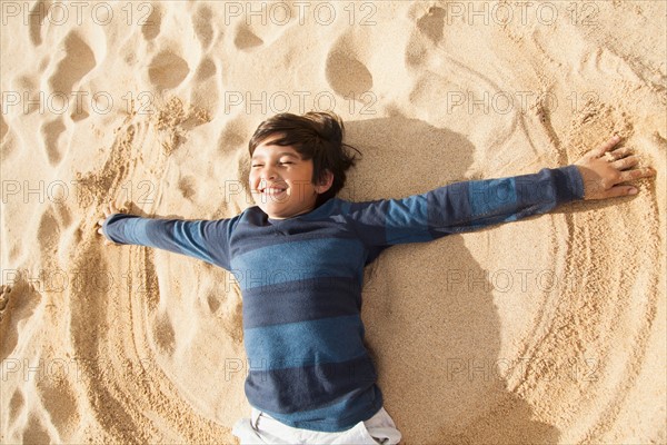 Boy (10-11) playing on beach