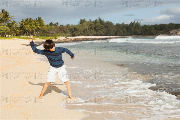 Boy (10-11) playing on beach