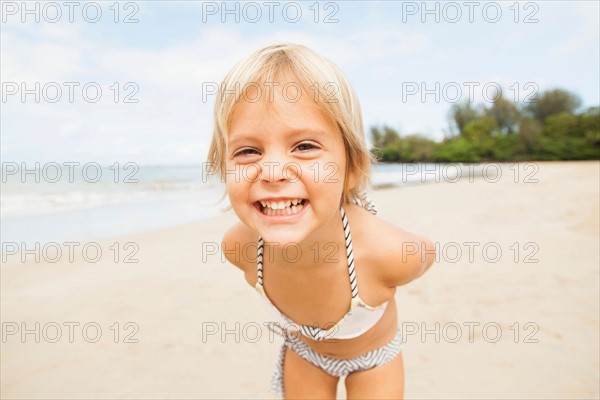 Smiling girl (2-3) on sandy beach