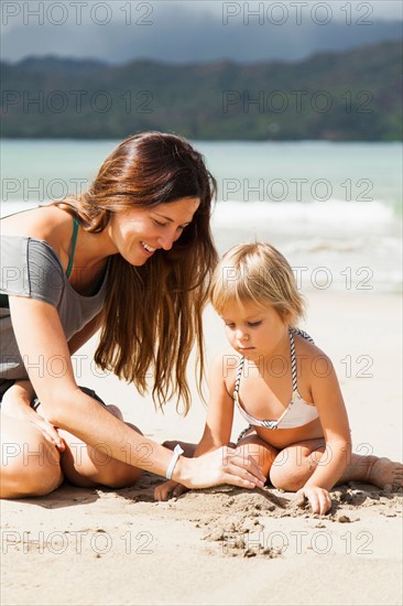 Mother playing with daughter (2-3) on beach