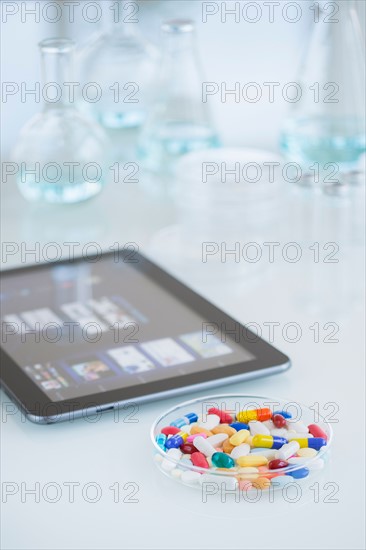 Studio shot of tablet pc and colorful pills.