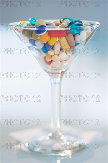 Studio shot of colorful pills in martini glass.