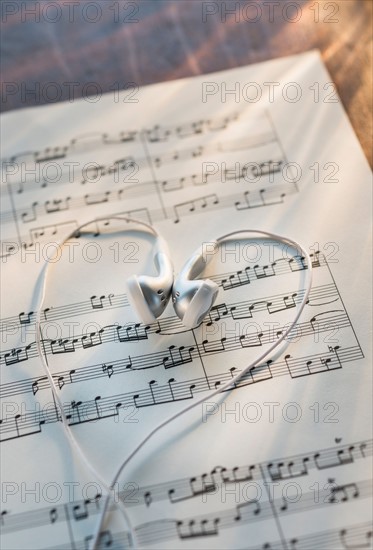 Studio shot of sheet music with earphones.