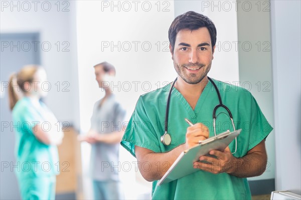 Portrait of male doctor in hospital hallway.