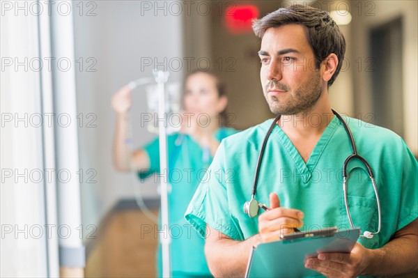 Male doctor in hospital hallway.