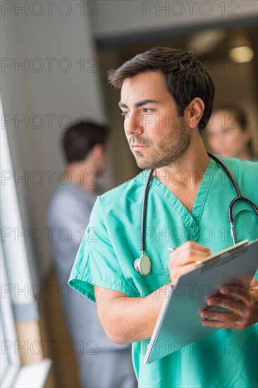 Male doctor in hospital hallway.