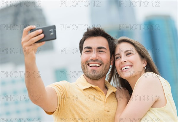 Couple taking self portrait photo with smartphone.