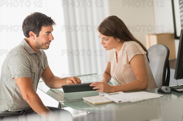 Man and woman talking in office.