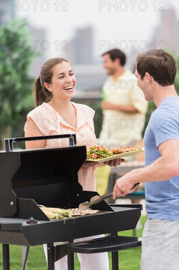 Friends enjoying barbecue in garden.