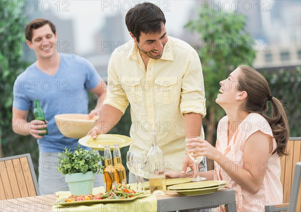 Friends enjoying barbecue in garden.