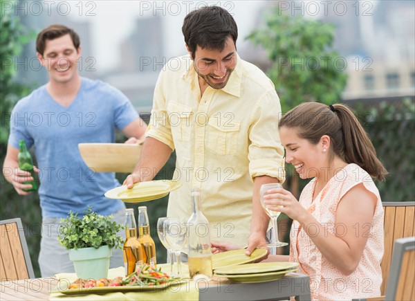 Friends enjoying barbecue in garden.