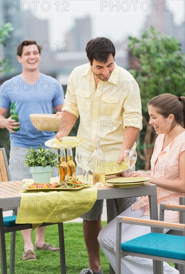 Friends enjoying barbecue in garden.