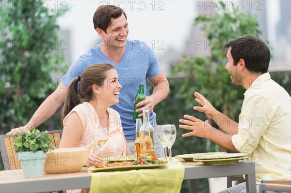 Friends enjoying barbecue in garden.