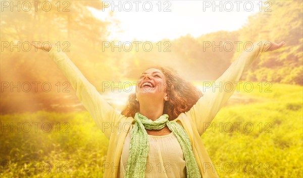 Woman reaching up to sunrays.