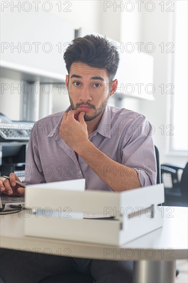 Portrait of businessman at work in office.