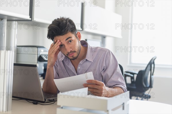 Portrait of businessman at work in office.