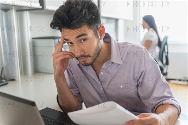 Portrait of businessman at work in office.