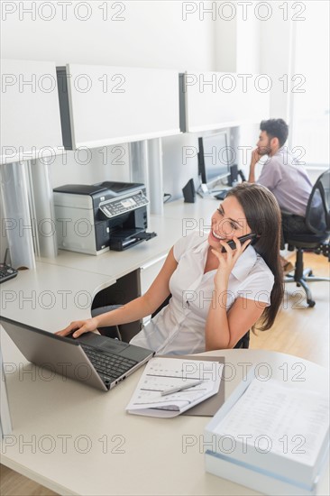 Woman talking on cell phone in office.