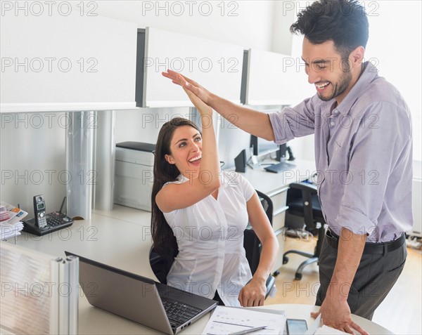 Woman and man giving high five to each other.