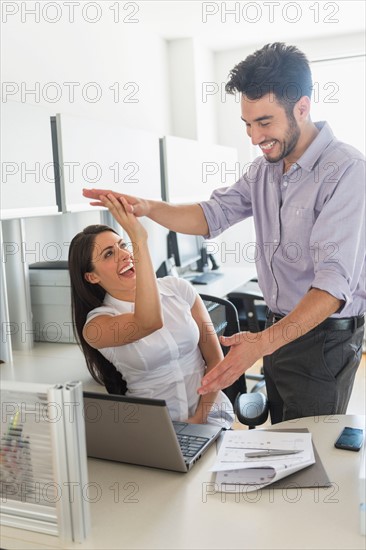 Woman and man giving high five to each other.