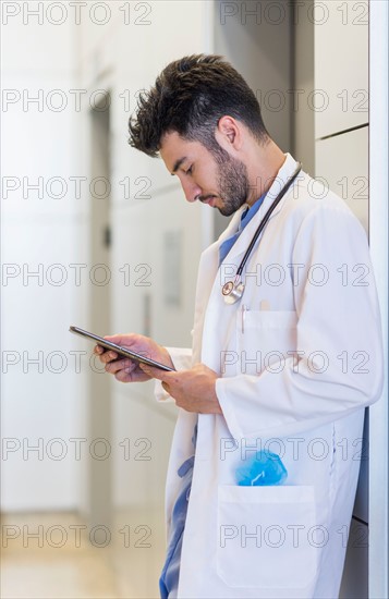 Doctor using digital tablet in hospital.